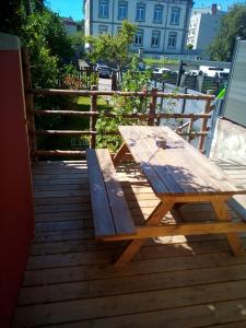 a wooden picnic table sitting on top of a deck at L'OASIS maisonnette centre ville 3 chambres terrasse espace vert privé parc sainte croix center parc 20 minutes in Sarrebourg