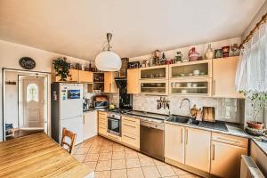 a kitchen with wooden cabinets and a white refrigerator at Petrův dům u mlýna in Slup
