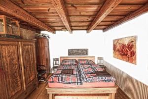 a bedroom with a bed and a wooden ceiling at Petrův dům u mlýna in Slup