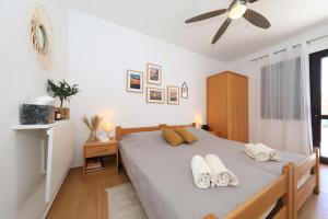 a bedroom with a bed and a ceiling fan at Hibis, No 2 in Starigrad