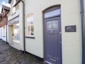 a blue door on the side of a building at Fern Cottage in Lichfield