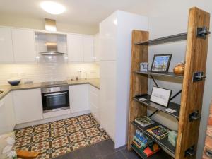 a kitchen with white cabinets and a stove top oven at Fern Cottage in Lichfield