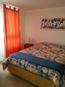 1 dormitorio con 1 cama con colcha colorida en Pamela Apartment, en Viña del Mar