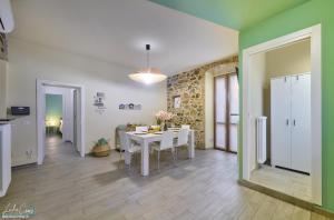 a kitchen and dining room with a white table and chairs at Daniel House - Lake and ferry terminal 1 minute walk, in the heart of Bellano in Bellano