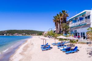a beach with chairs and umbrellas and the ocean at Dimitra Beach Apartments 2 in Nea Karvali