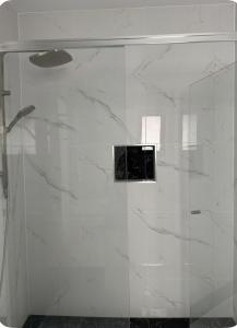 a shower with a glass door in a bathroom at Modern Suite Near Adelaide CBD in Woodville