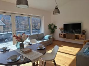 a living room with a table and a couch at Penthouse mit Seeblick & Terrasse Top 7 in Reifnitz