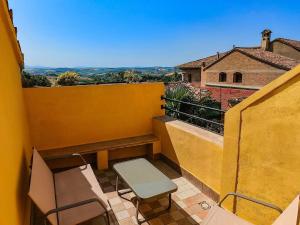 a balcony with chairs and a bench on a building at I Segreti del Borgo - Cosmopolitan in Ostra