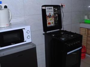 a kitchen with a microwave and a stove at Comfy one bedroom in Membly Ruiru in Ruiru