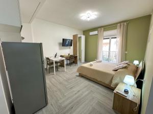 a bedroom with a bed and a table and a dining room at Ferrera Suite & Rooms in Misterbianco