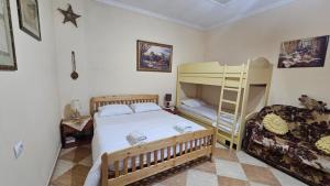 a bedroom with a bunk bed and a couch at Honey-House Kastrioti Adventures in Përmet