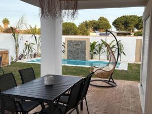 a patio with a table and chairs and a swing at GUACAMAYOS in Cádiz