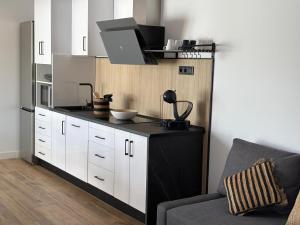 a kitchen with a black counter and white cabinets at GUACAMAYOS in Cádiz