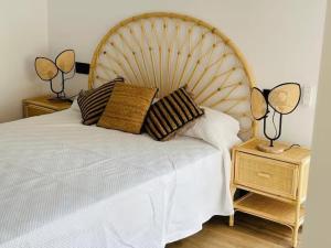 a bedroom with a white bed with two lamps on a night stand at GUACAMAYOS in Cádiz