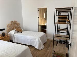 a room with two beds and a mirror and a ladder at GUACAMAYOS in Cádiz