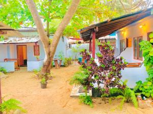 a house with trees and plants in front of it at Blue Vibe in Arugam Bay