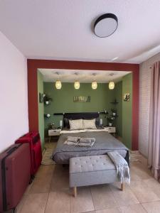 a bedroom with a bed and a red and green wall at Casa Barmalei Private Pool & Rooftop Terrace Ocean View, Tenerife in Callao Salvaje