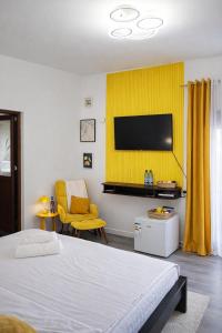 a bedroom with a bed and a yellow wall at The Green House - Jacuzzi & Garden Escape in Timişoara
