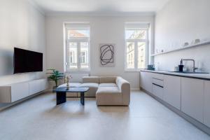 a white living room with a couch and a table at Palmotić Heritage Suites - Main Square - FREE Parking in Zagreb