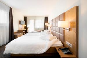 a hotel room with four beds and a telephone at Hotel Olympic - Montana Center in Crans-Montana