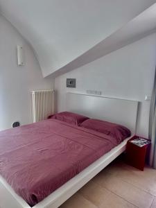 a bed with a red comforter in a bedroom at VastoMare - appartamento Vasto Marina in Vasto