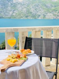 ein Tisch mit einem Teller Essen und einem Glas Orangensaft in der Unterkunft Villa Blanca - Risan in Risan