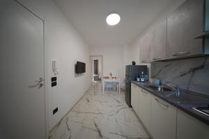 a kitchen with white cabinets and a marble floor at La Casa Di Nonna in Licusati