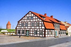a black and white building with an orange roof at Heritage House in Klaipėda