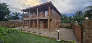 a house with a balcony on top of a yard at Moradia Pérola da Natureza in Lemos