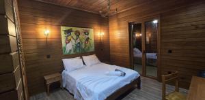 a bedroom with a bed in a wooden room at Moradia Pérola da Natureza in Lemos +27 photos