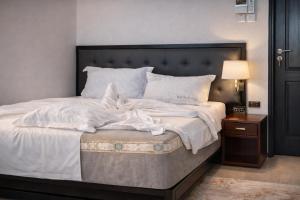 a bedroom with a large bed with white sheets at Mach Hotel in Dar es Salaam