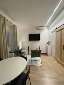 a living room with a table and chairs and a tv at La Maison De Rennì in Viterbo