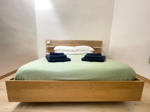 a bed with green sheets and blue towels on it at La Maison De Rennì in Viterbo