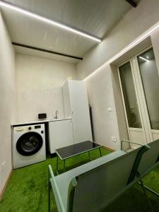 a laundry room with a table and a washing machine at La Maison De Rennì in Viterbo