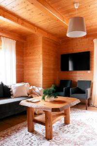 a living room with a couch and a table at Domki Bystre in Baligród +15 photos