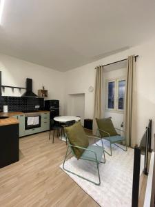 a living room with green chairs and a table at La Maison De Rennì in Viterbo