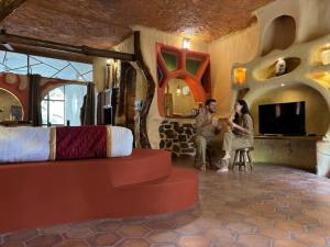 a man and woman sitting in a room with a bed at Udaya Resort in Palakkad