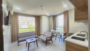 a living room with a couch and chairs and a table at LTG Grand Hotel Cebu in Cebu City