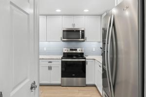 a kitchen with a stove and a refrigerator at Sunset Captiva Bayside Unit 103 condo in Captiva