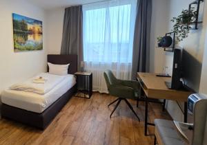 a bedroom with a bed and a desk with a computer at Hotel Handelshof in Bünde
