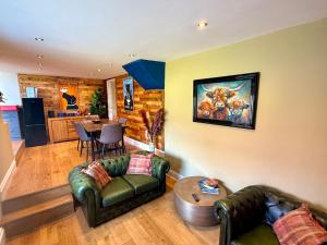 a living room with two leather couches and a table at High Cross House in Millbrook