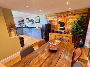 a dining room with a wooden table and a kitchen at High Cross House in Millbrook