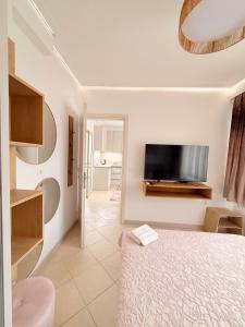 a bedroom with a bed and a flat screen tv at Villa Sunrice in Nea Peramos