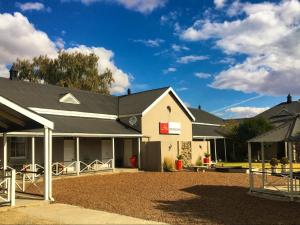 a white building with a black roof at Hendersons Lodge Ltd in Senekal