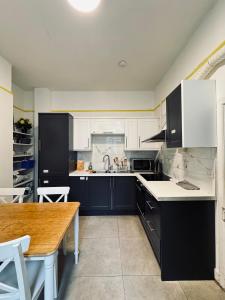 a kitchen with black and white cabinets and a wooden table at 13 Frankfield Terrace, Summerhill South, Cork, T12 PY79 in Cork