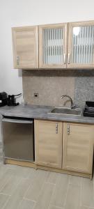 a kitchen with wooden cabinets and a sink at A&Bpikermistudios2 in Pikérmion +6 photos