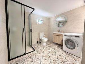 a bathroom with a toilet and a washing machine at Villa Sunrice in Nea Peramos