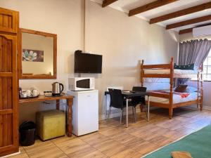 a room with a desk and a table with a microwave at Hendersons Lodge Ltd in Senekal