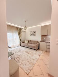 a living room with a couch and a kitchen at Villa Sunrice in Nea Peramos