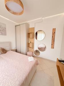 a bedroom with a bed and two mirrors on the wall at Villa Sunrice in Nea Peramos